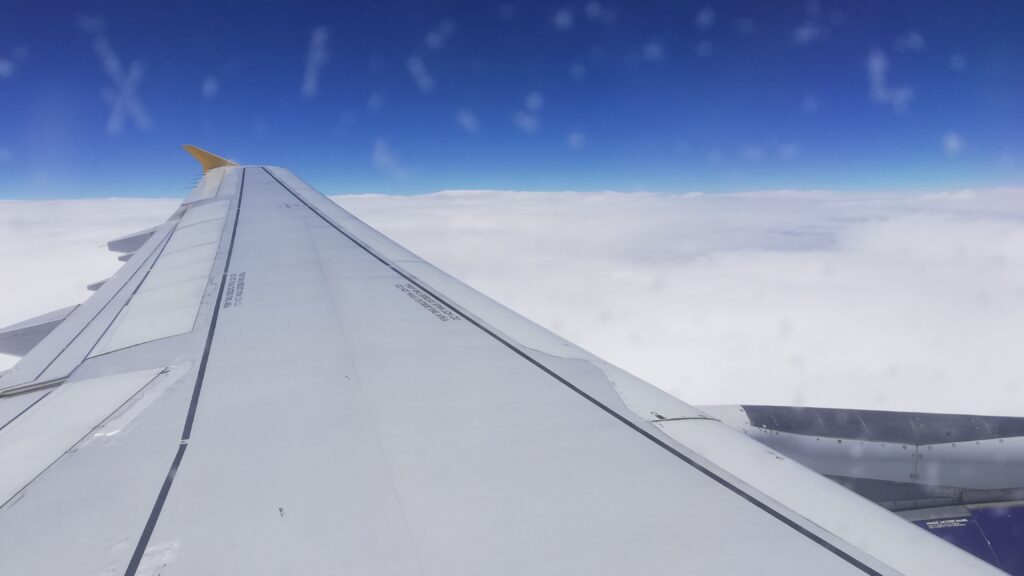 View from a plane window looking over clouds