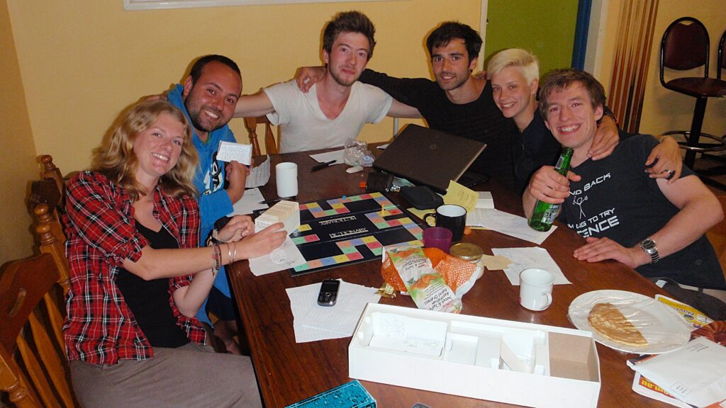 A group of young adults sat around a table playing a board game