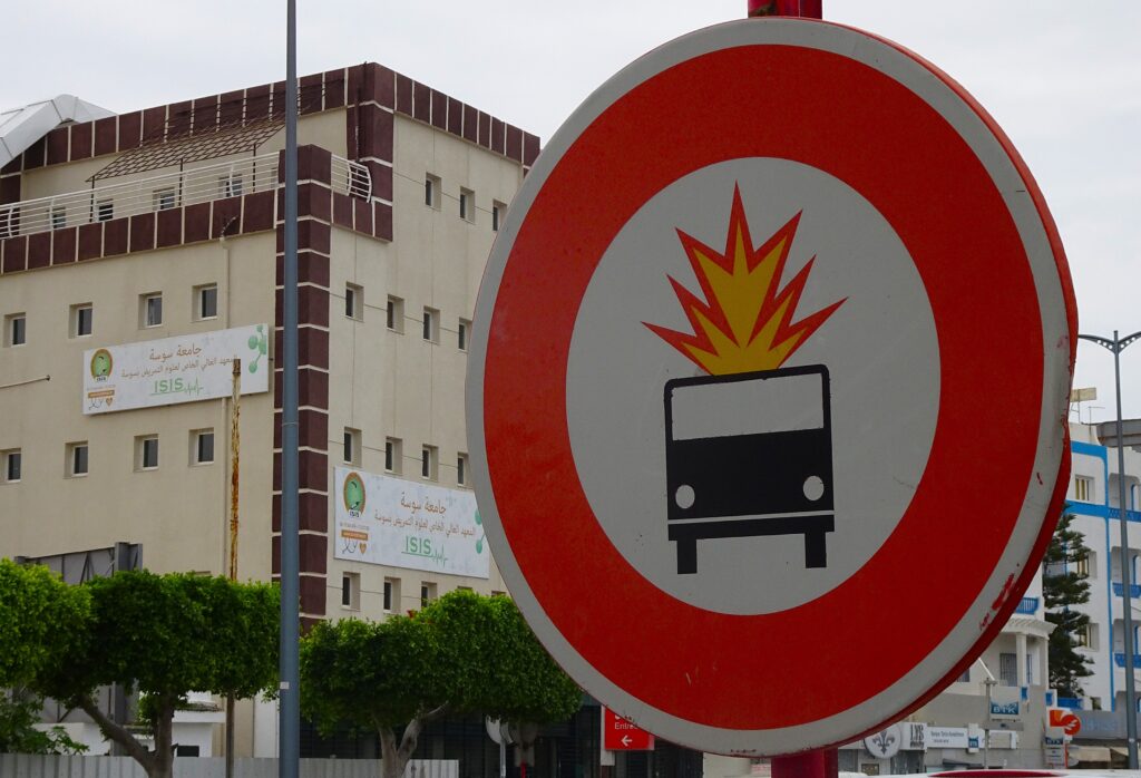 Red circular road sign depicting an exploding car