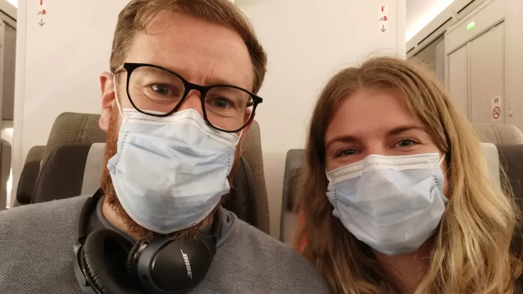 A young couple wearing covid masks on public transport