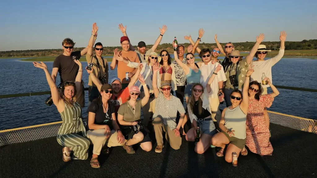 Group of young adults on top of a boat having fun