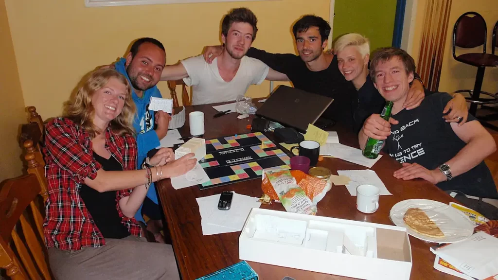 A group of young adults sat around a table playing a board game