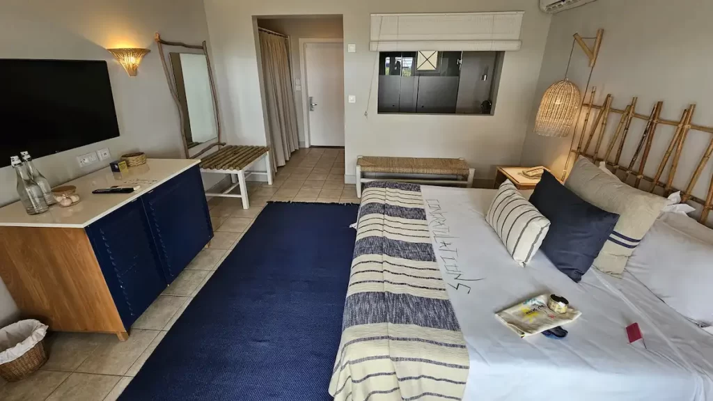 A large hotel room decorated with navy blue and wooden decor