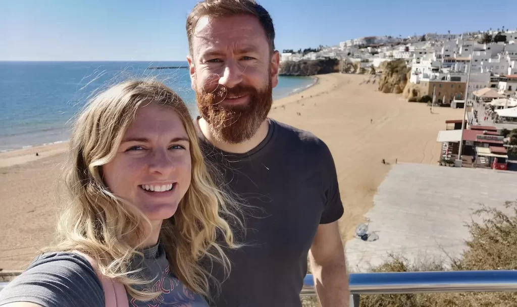 A couple smiling together overlooking Albufeira beach