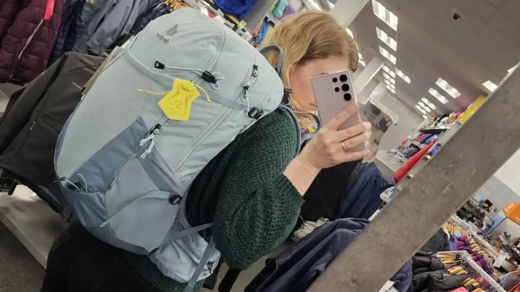 A mirror selfie showing a light blue backpack