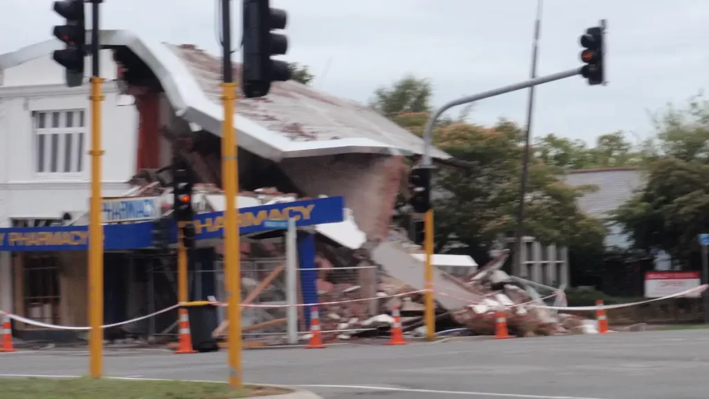A blurry image of a pharmacy which has collapsed on one side