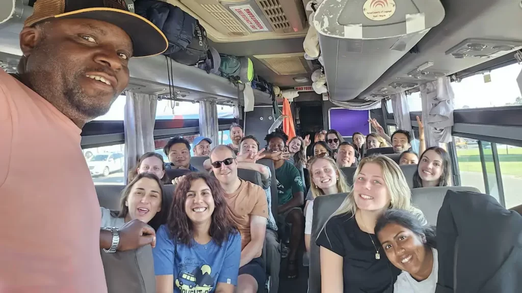 A selfie style photo taken by a tour guide of him and all his tour group inside a bus