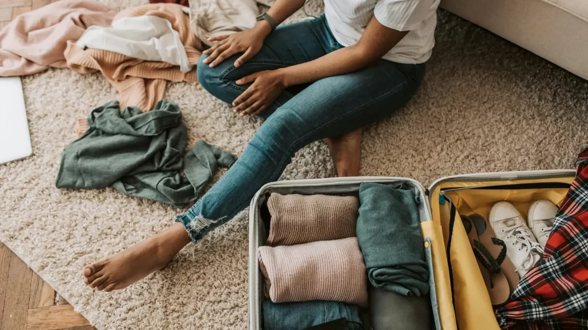 Birds eye view of an open suitcase and a woman sat next to it