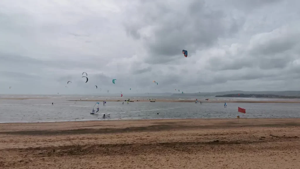 Kitesurfers on the ocean under a moody grey sky