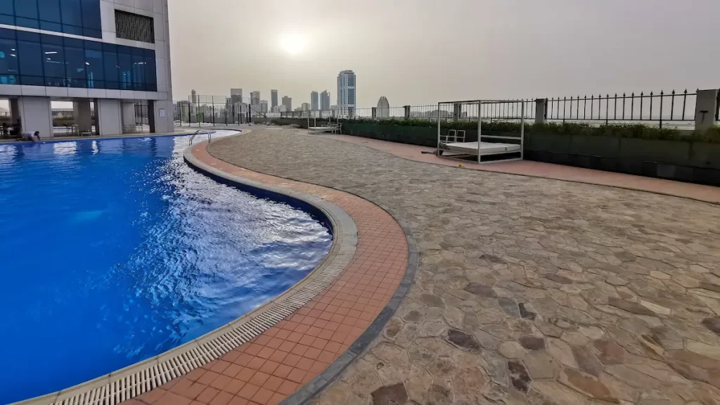 A swimming pool and lounge area on top of a skyscraper