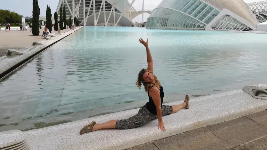 Woman doing the splits in front of blue water at Valencia Science Park