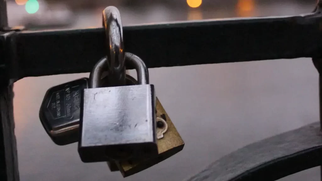 Close up of several padlocks attached to a bridge