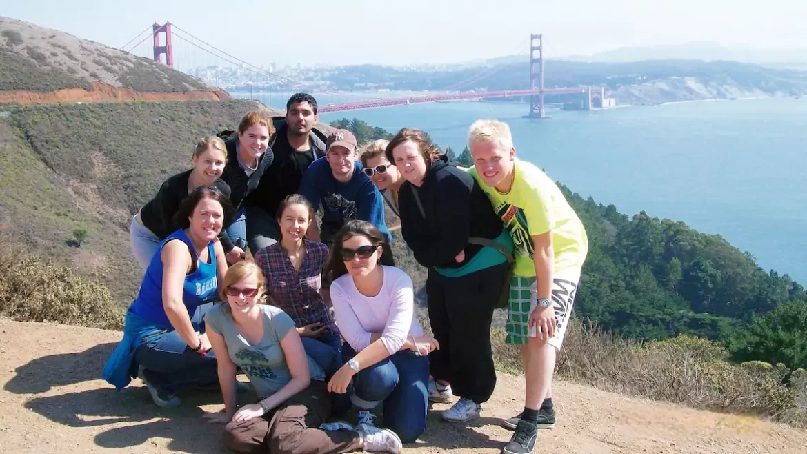 Group of young adults on a hill with the Golden Gate Bridge in the background