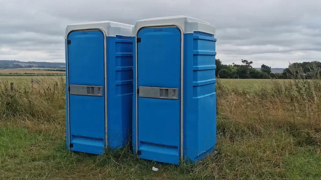 Blue Portaloos in a field