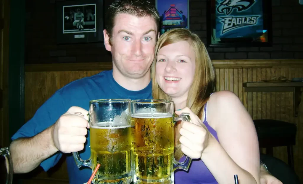 A couple holding up two giant beers
