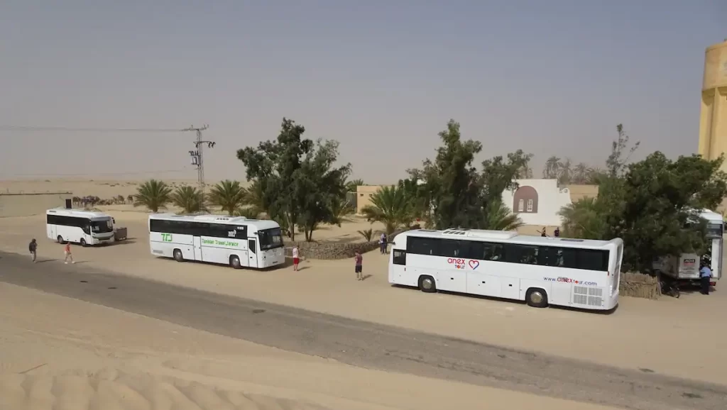 Three white coaches in a sandy desert