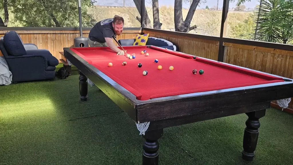 Man playing snooker on a red snooker table