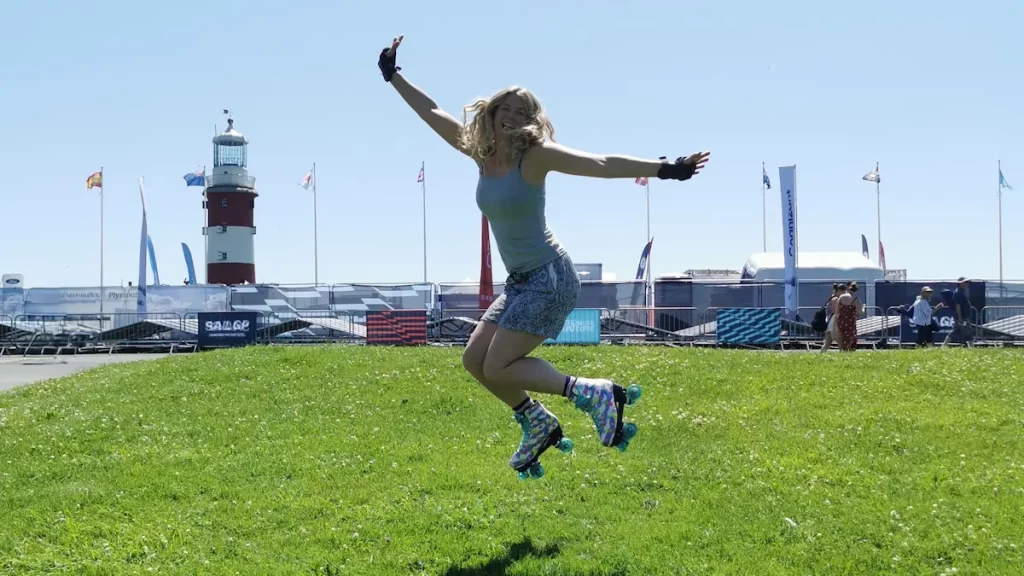 Woman jumping on the grass with roller skates on