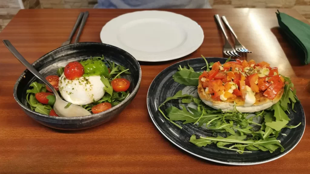 Two plates of rocket salad and bruschetta