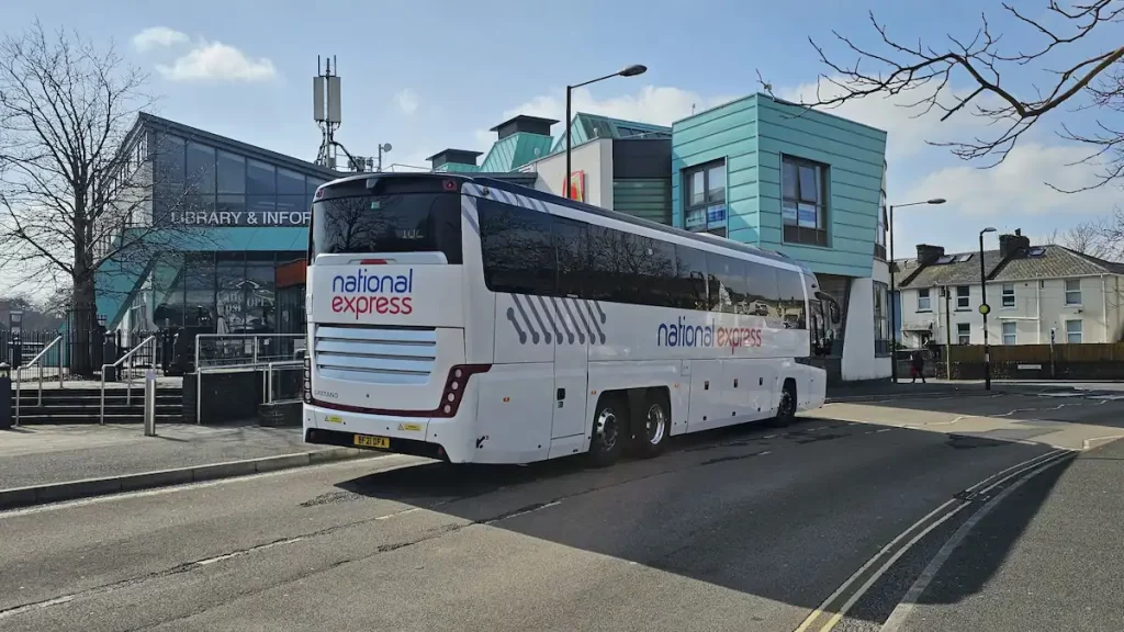 A National Express coach parked outside a library