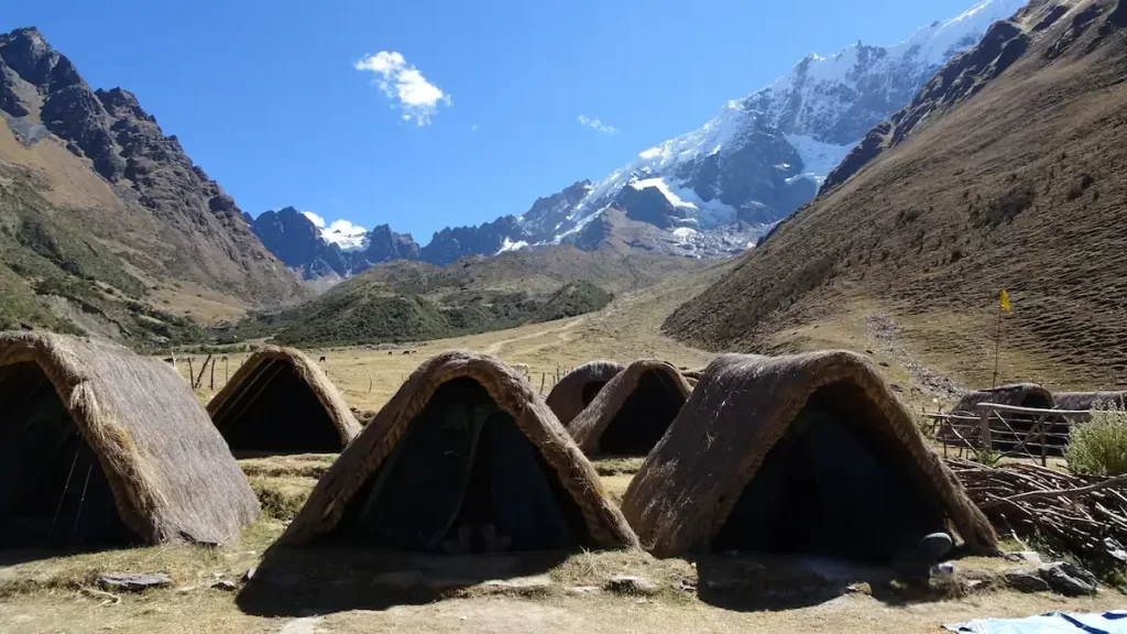 Pitched tents with snow capped mountains in the background